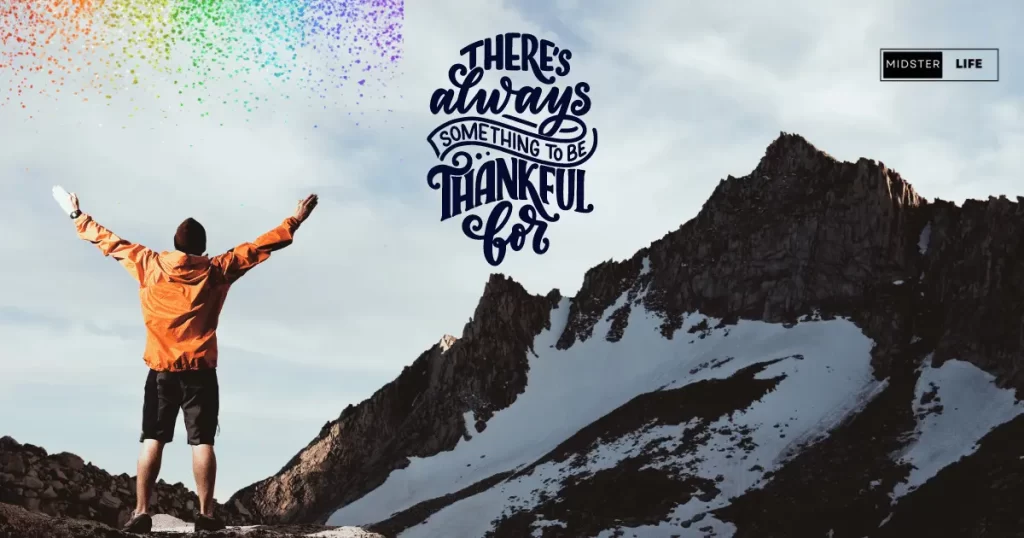 Man standing on mountain looking up at the peak with his arms out wide, with a rainbow of color above him. Accompanying text: "There's always something to be thankful for".