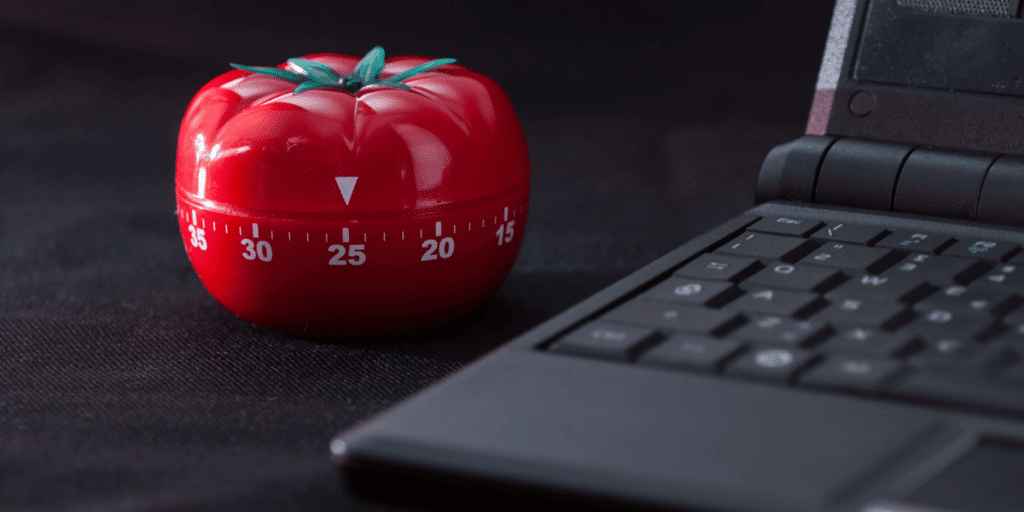 Pomodoro Timer on a table next to a laptop