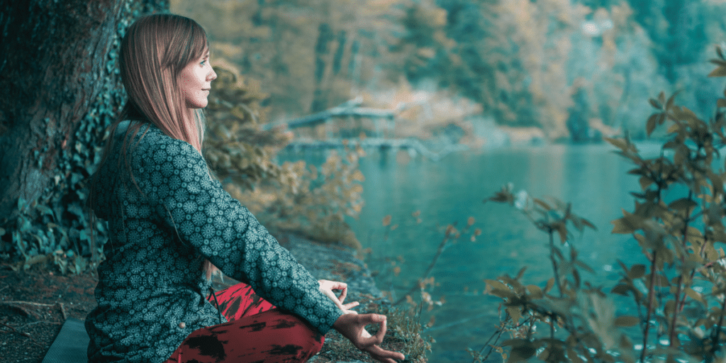 Conquer Limiting Beliefs After 40: Mindfulness and Meditation Practices. A Woman meditating by a river.